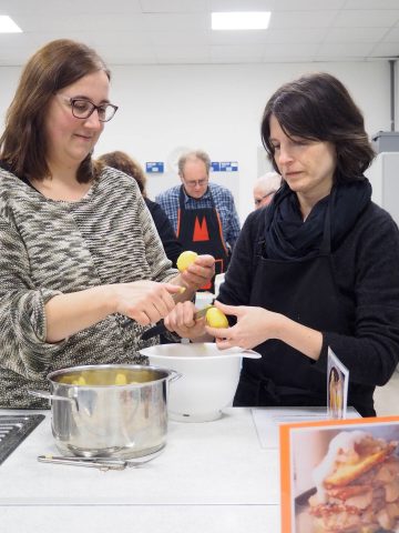 Teilnehmerinnen beim Kartoffel schälen
